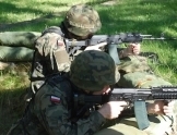 Dwaj mężczyźni ubrani w stroje moro z karabinami w ręku